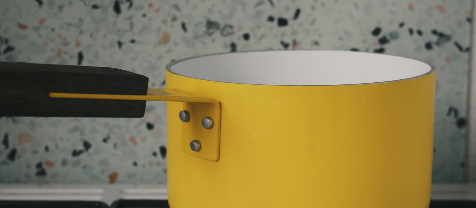 A yellow pot sitting on a gas hob