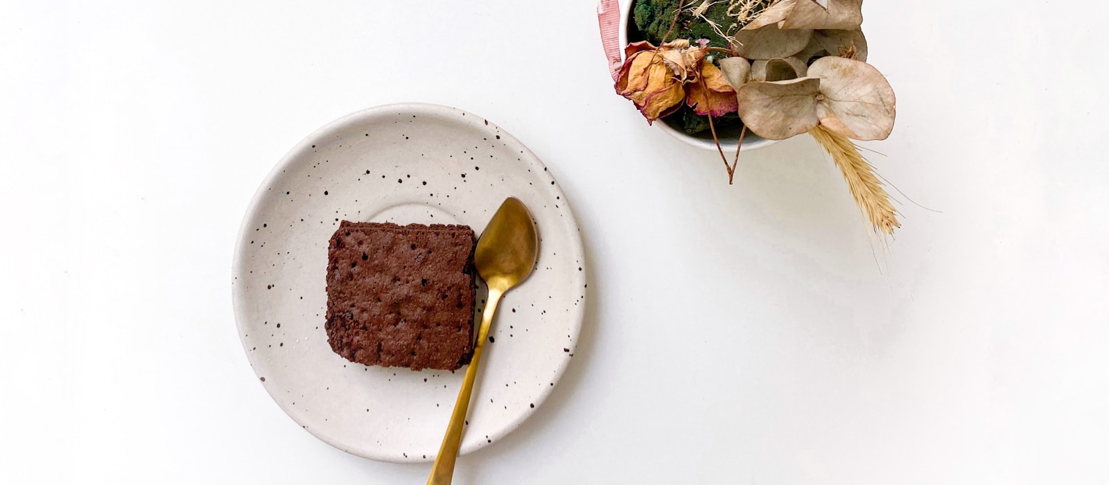 A single small brownie on a white plate