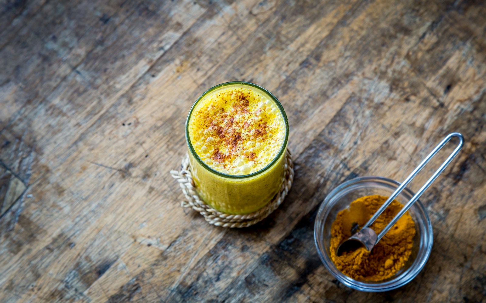 A golden turmeric latte in a glass mug with cinnamon on top