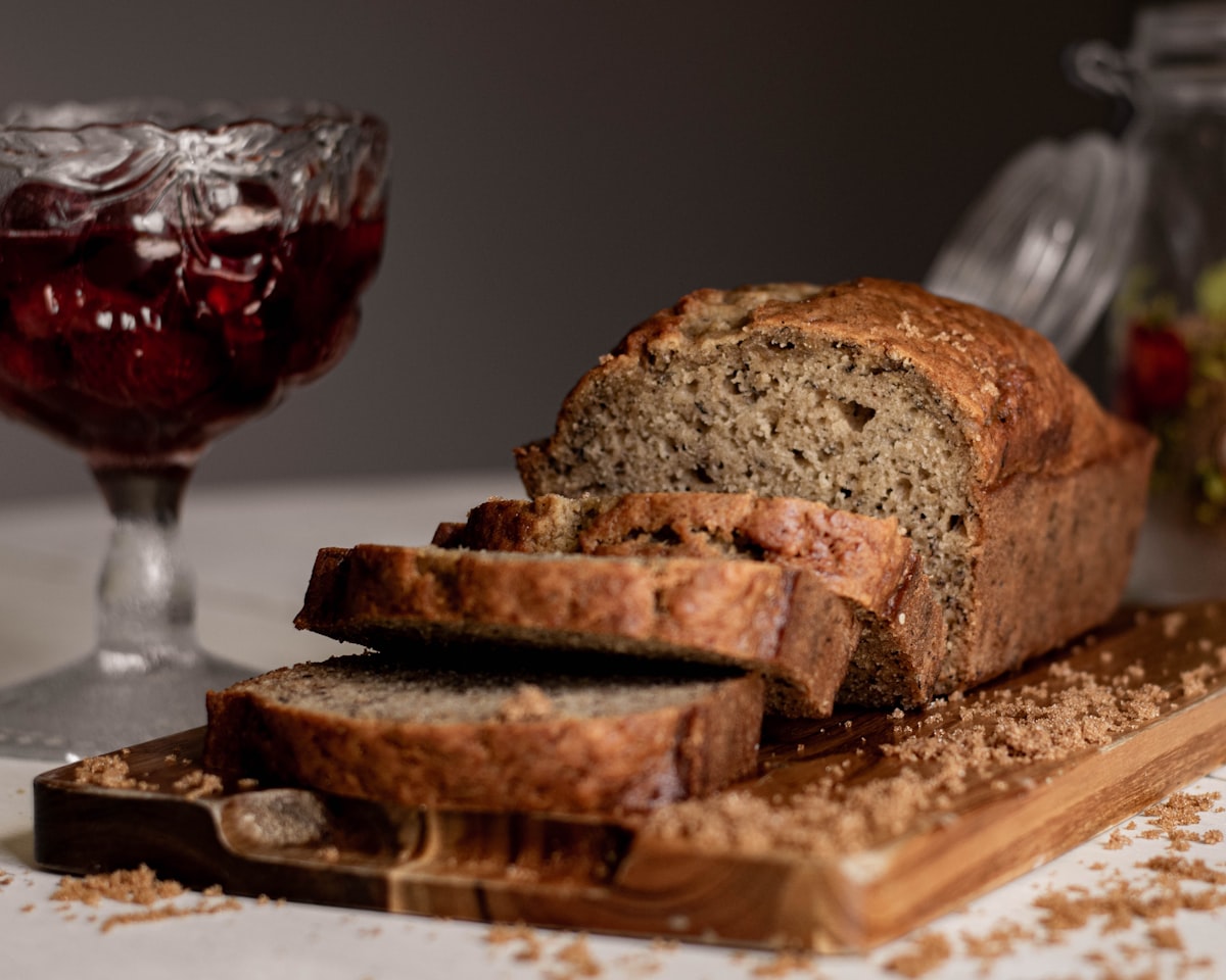 A sliced loaf of banana bread on a wooden board