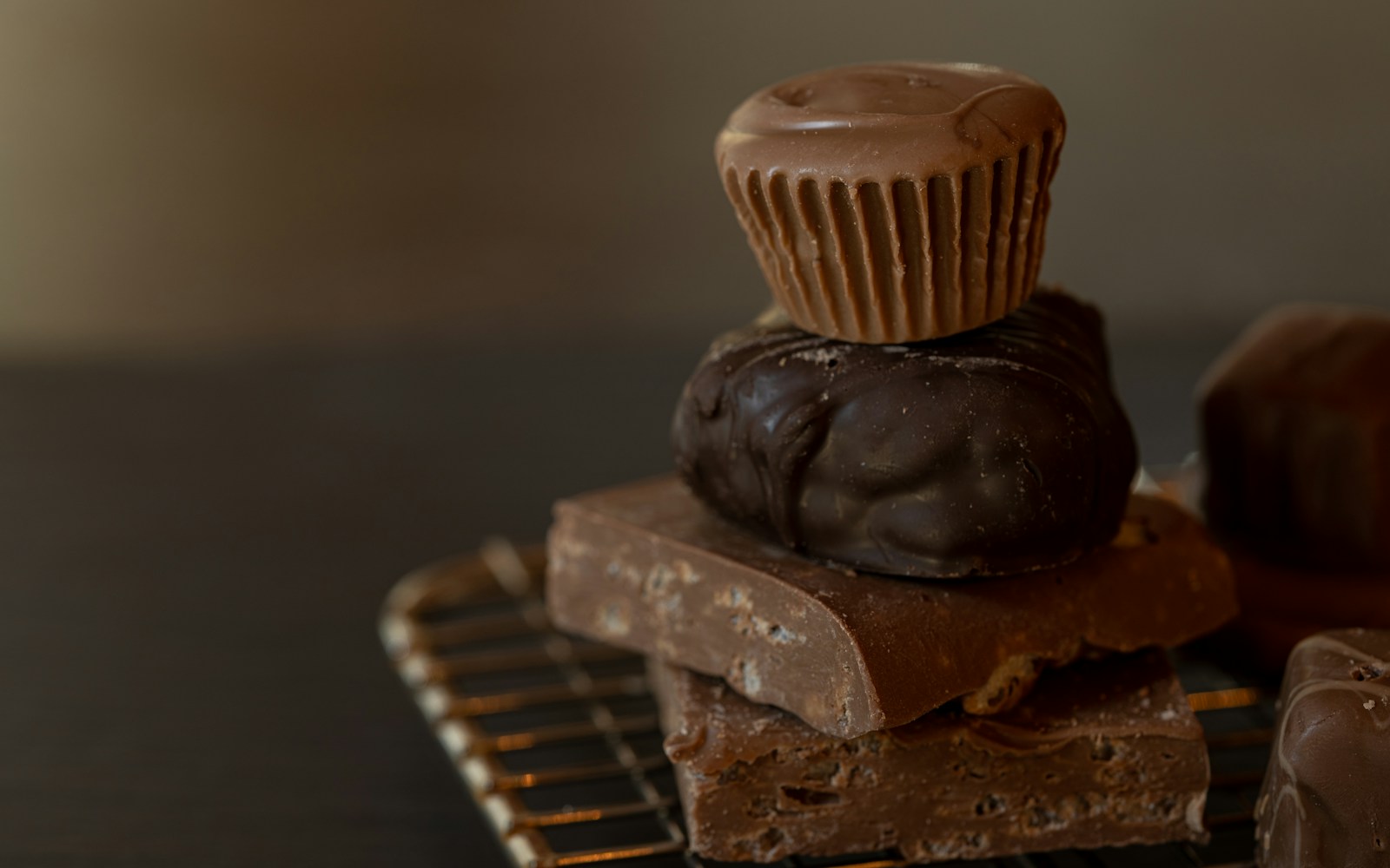 Homemade dark chocolate peanut butter cups on parchment, one bitten